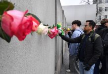 Berlin commemorates fall of Berlin Wall 36 years ago People place flowers to mark the 36th anniversary of the Berlin wall fall, at the Wall memorial on Bernauer Strasse. Credit: Paul Zinken/dpa